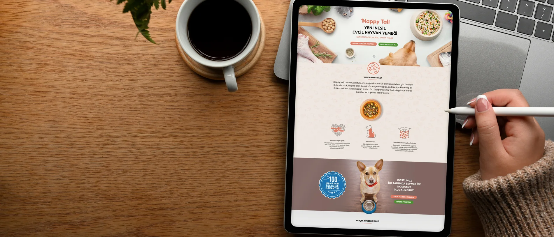 A hand using a stylus on a tablet showing the Happy Tail website, on a wooden table beside a coffee cup